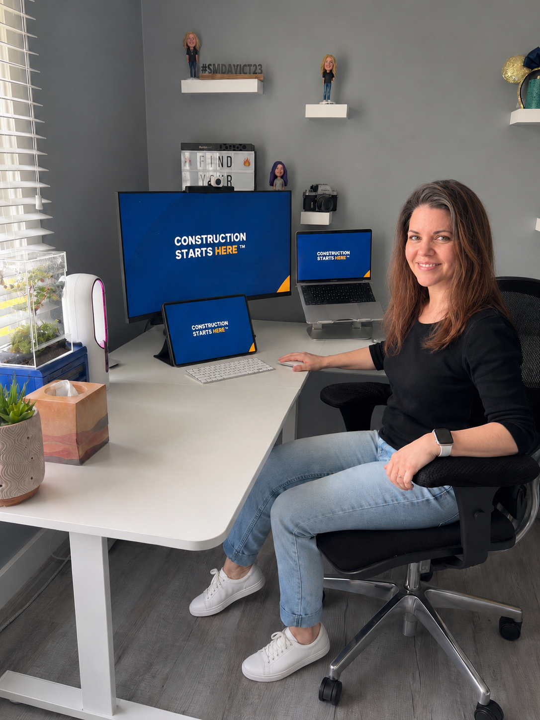 Julie Riley at her desk working on ConstructConnect social media